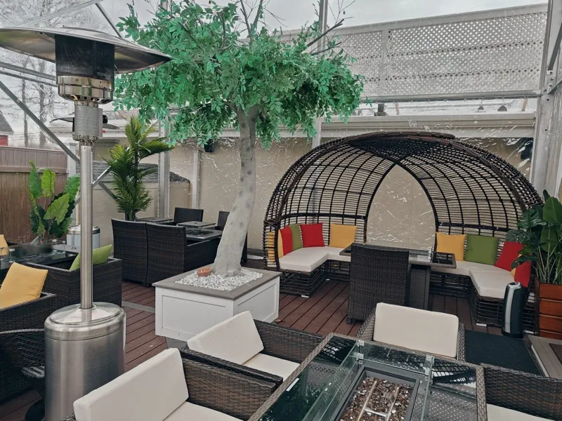 Heated patio seating with a fire table and a rattan dome booth